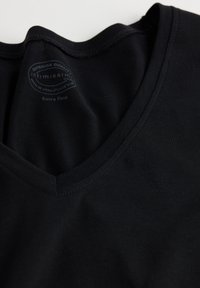 Zwarte V-hals T-shirt gemaakt van zacht katoen, met een gladde textuur en een label met de merknaam en wasinstructies zichtbaar.