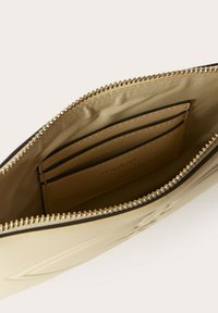 Borsa beige con zip, dalla superficie liscia, dotata di scomparti per carte all'interno e fodera in raso, arricchita con hardware in tonalità oro.