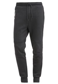 Svarta avsmalnande sweatpants med elastisk midja, justerbar dragsko, blixtlåsficka på sidan och ribbade mudd vid anklarna.