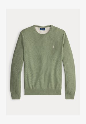 Zaļš adīts džemperis ar apaļu kakla izgriezumu. Uz kreisā krūšu daļas ir neliels izšūts logo, kā arī ribotas piedurknes un apakšmalas.