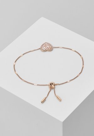 Délicat bracelet en or rose avec chaîne réglable et pendentif en forme de cœur incrusté de petites pierres rose clair.