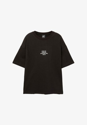 T-shirt noir oversize à manches courtes. Présente un texte blanc : "STWD ART EXHIBITION SUR RENDEZ-VOUS UNIQUEMENT CIRCA 91" au centre devant. Matière en coton.