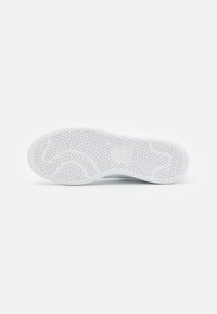 Weiße Sneaker-Sohle mit einem strukturierten hexagonalen Muster und glatten Kanten. Verfügt über ein Logo im Fersenbereich zur Markenkennzeichnung.