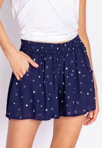 Navyblauwe shorts met een sterpatroon in lichtblauw, voorzien van een elastische tailleband en zijzakken. Zacht, lichtgewicht stof met een relaxte pasvorm.