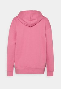 Rosa hoodie med ett mjukt tyg, avslappnad passform och huva. Sömdetaljer och ribbade muddar förbättrar dess form och textur.