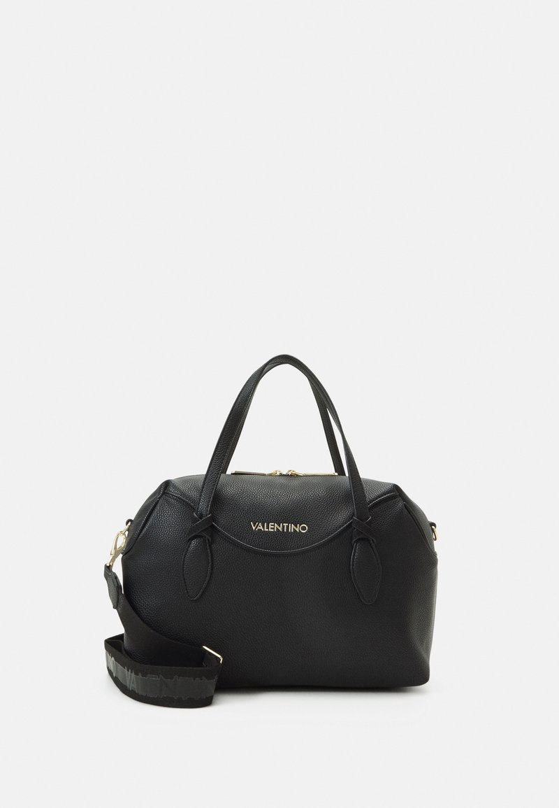 Sac à main en cuir noir avec finition texturée, poignées doubles, bandoulière amovible, détail en logo doré à l'avant, et fermeture éclair en haut.