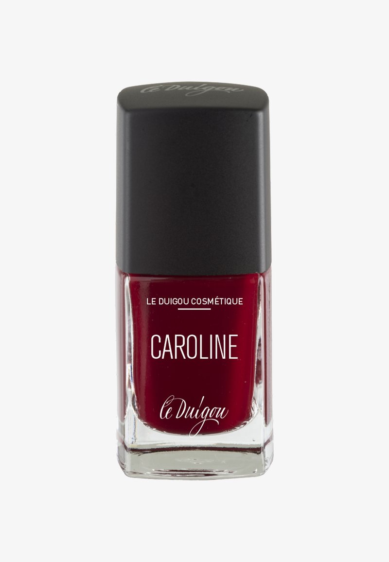 Bottiglia di smalto per unghie con un tappo quadrato nero e una base di vetro trasparente, riempita con smalto di un rosso intenso. L'etichetta riporta la scritta "CAROLINE" e il nome del marchio.