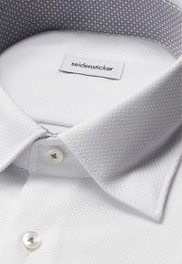 Witte gemarmerde overhemddress met een gladde grijze patroonkraag, voorzien van een Seidensticker-label en witte knoopsluitingen.