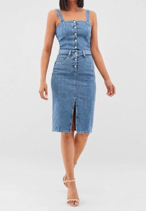 Femme portant une robe en denim bleu ajustée avec des boutons sur le devant, une fente à l'avant et des fines bretelles, associée à des talons beige à bride à la cheville.