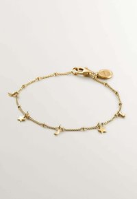 Pulsera de cadena de oro con encantos de estrella y luna creciente, eslabones texturizados y cierre con un pequeño tag redondo.