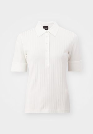 Hvit ribbet polo skjorte med korte ermer, knappestolpe foran og spiss krage. Har en myk tekstur og subtile design detaljer.