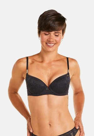 Soutien-gorge en dentelle noire avec un design rembourré et sous-vêtement, orné de motifs floraux, de bretelles ajustables et d'accents décoratifs au niveau des bretelles.