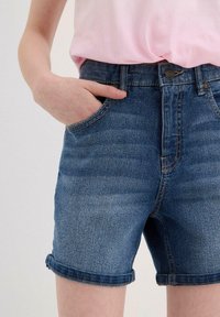 Shorts in denim blu scuro con una finitura sfumata, dotati di due tasche anteriori e risvolti. Progettati con una vita e chiusura a bottone.