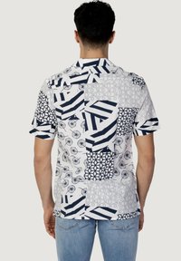 Korte mouwenshirt met een mix van geometrische patronen in marineblauw en wit, gemaakt van lichte stof met een relaxte pasvorm.