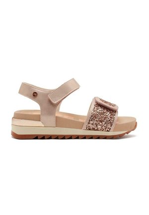 Sandalo beige con una fascia glitterata testurizzata, chiusura in velcro regolabile, soletta imbottita e suola bianca e beige a contrasto.