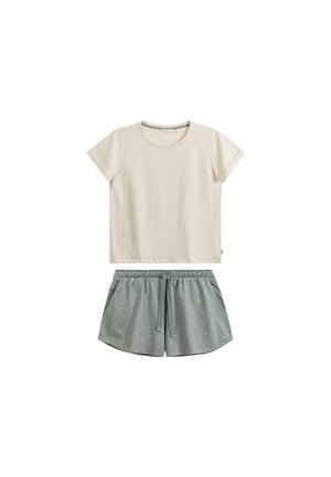 Kremowa koszula z krótkim rękawem zestawiona z niebiesko-zielonymi szortami z troczkiem, ozdobionymi drobnym białym wzorem.