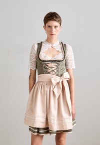 Tradicionalna dirndl obleka z zelenim korzetom z čipkastimi detajli, rožnatimi trakovi in razširjeno rožnato krilo z okrasnim robom.