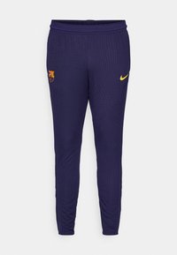 Marine atletikbukser med ribbet tekstur, gul Nike-logo og Barcelona klubmærke på låret. Elastisk talje for komfort.