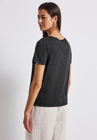 Black cotton t-shirt with a crew neckline and short sleeves, featuring a relaxed fit and a soft, slightly textured surface.