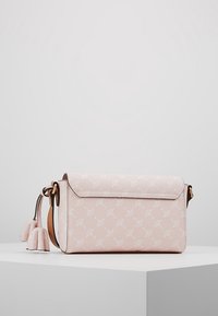 Borsa a tracolla rosa chiaro con finitura testurizzata, caratterizzata da un motivo bianco, una chiusura a patta e un dettaglio decorativo con frangia.