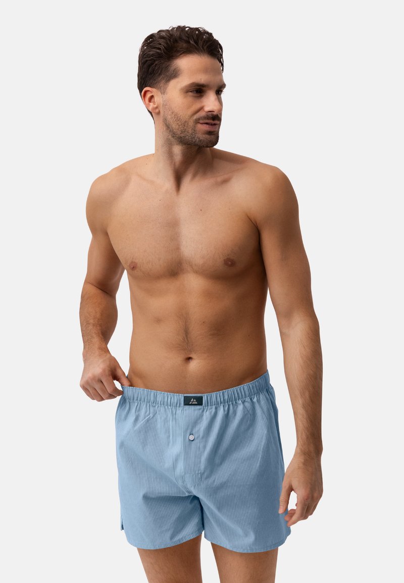 Pantaloni boxer a strisce azzurro chiaro con fascia elastica in vita, chiusura a bottone e vestibilità ample. Il tessuto sembra morbido e confortevole.