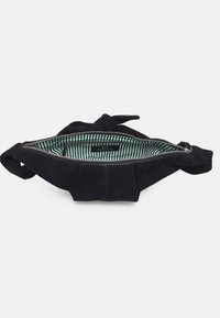 Sac en daim noir avec une ouverture zippée, présentant un intérieur rayé vert et blanc, et des accents noués sur les côtés.