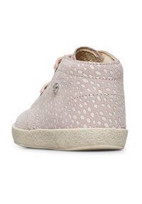 Sneaker in suede rosa chiaro con motivo a pois perforati, suola in gomma bianca e punta arrotondata. Presenta chiusura con lacci e dettaglio in metallo.