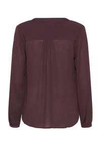 Hedvábná halenka s dlouhým rukávem v hluboké burgundské barvě, vyrobená z průhledné tkaniny, se zdobným detailem na zádech a knoflíkovými manžetami pro uvolněný střih.