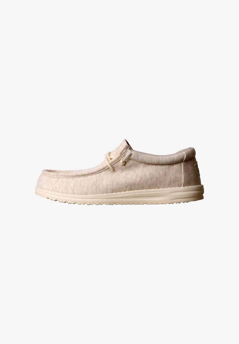 Chaussure beige décontractée à enfiler avec coutures style mocassin, tige en tissu, col rembourré et semelle en caoutchouc texturée, vue de profil.