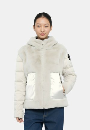 Giacca in pelliccia sintetica di colore grigio chiaro con un design voluminoso, cappuccio e tasche frontali lucide argentate. Caratterizzata da una chiusura con zip e dettagli in tessuto testurizzato.