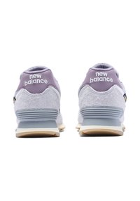 Szürke �és levendula színű New Balance sportcipők, textúrált velúr felsőrésszel, fehér logóval és világosszürke középtalppal, gumitalppal ellátva.