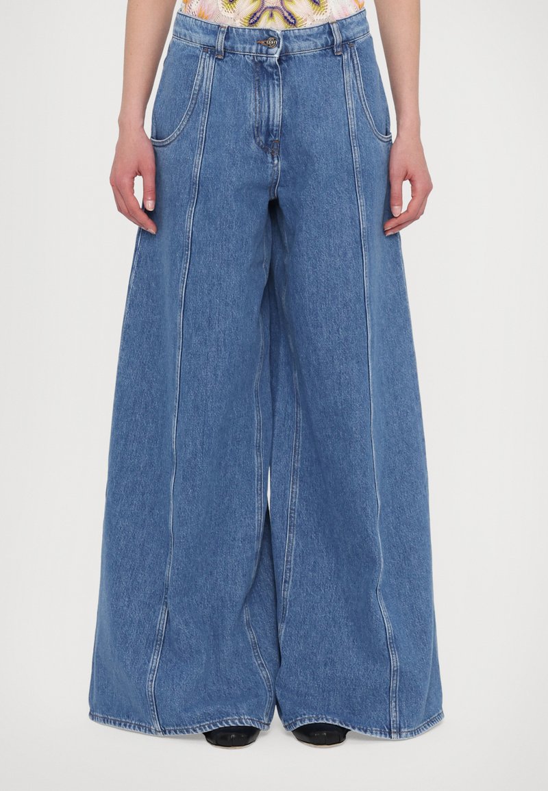 Wide-leg denim trousers in light blue, featuring a high waist, front pockets, and stitching details along the seams.