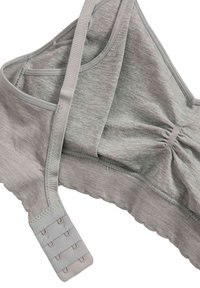 Lichtgrijze zachte stoffen bralette met verstelbare bandjes en een haak-en-oogsluiting op een witte achtergrond.