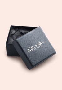 Schmuckbox aus schwarzem Textil mit weichem Innenraum und offenem Deckel, oben mit weißem Markentext "Sofia Milani Jewels".