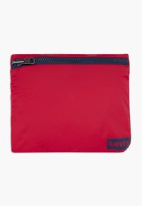 Röd zippered fodral gjort av lätt material med en slät textur. Har en kontrasterande marinblå dragkedja och en svart Levi's-logotyp.