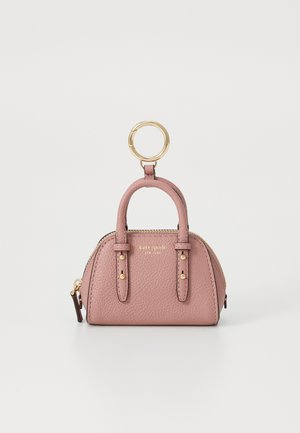 Malá dusty růžová kožená taštička Kate Spade so zlatým zipsom, dvojitými uchami a pripojeným zlatým krúžkom na kľúče na bielom pozadí.
