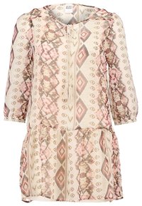 Vestido ligero de manga larga en beige con un patrón geométrico en rosa y marrón, que cuenta con cuello con cordón y falda acampanada.