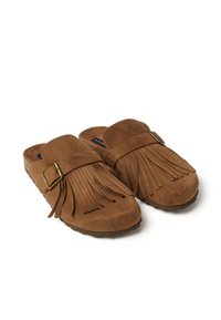 Scarpe slip-on in suede marrone con frange frontali e cinturino regolabile in ottone, angolate affiancate su sfondo bianco.