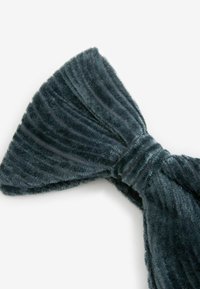 Dunkelgraue Kordelband mit ribbed Textur, die eine zentrale geraffte Sektion aufweist. Der Stoff scheint weich und plüschig zu sein.