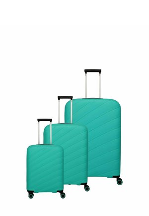 Tre valigie rigide di colore turchese chiaro. Ogni valigia presenta un design a strisce diagonali testurizzate e manici neri estensibili.