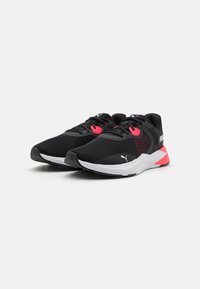 Black athletic sneakers with a mesh upper, pink accents on the laces and heel, and a white midsole; streamlined design for performance.