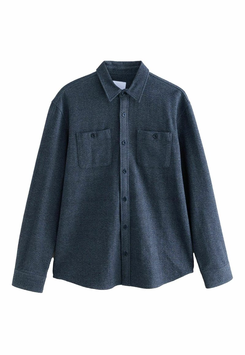 Cămașă lungă cu mânecă închisă la culoare, gri închis, cu guler tip button-down, două buzunare pe piept și un finisaj din material texturat. Prezintă șase butoane pe față.