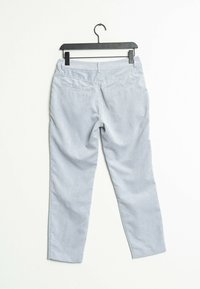 Ljust blå kordflorbyxor med en texturerad yta, med raka ben och bakfickor, hängande på en svart galge.