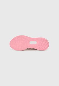 Light-colored sneaker sole with a textured pink rubber bottom, featuring a round cutout in the midsole and tread pattern for traction.