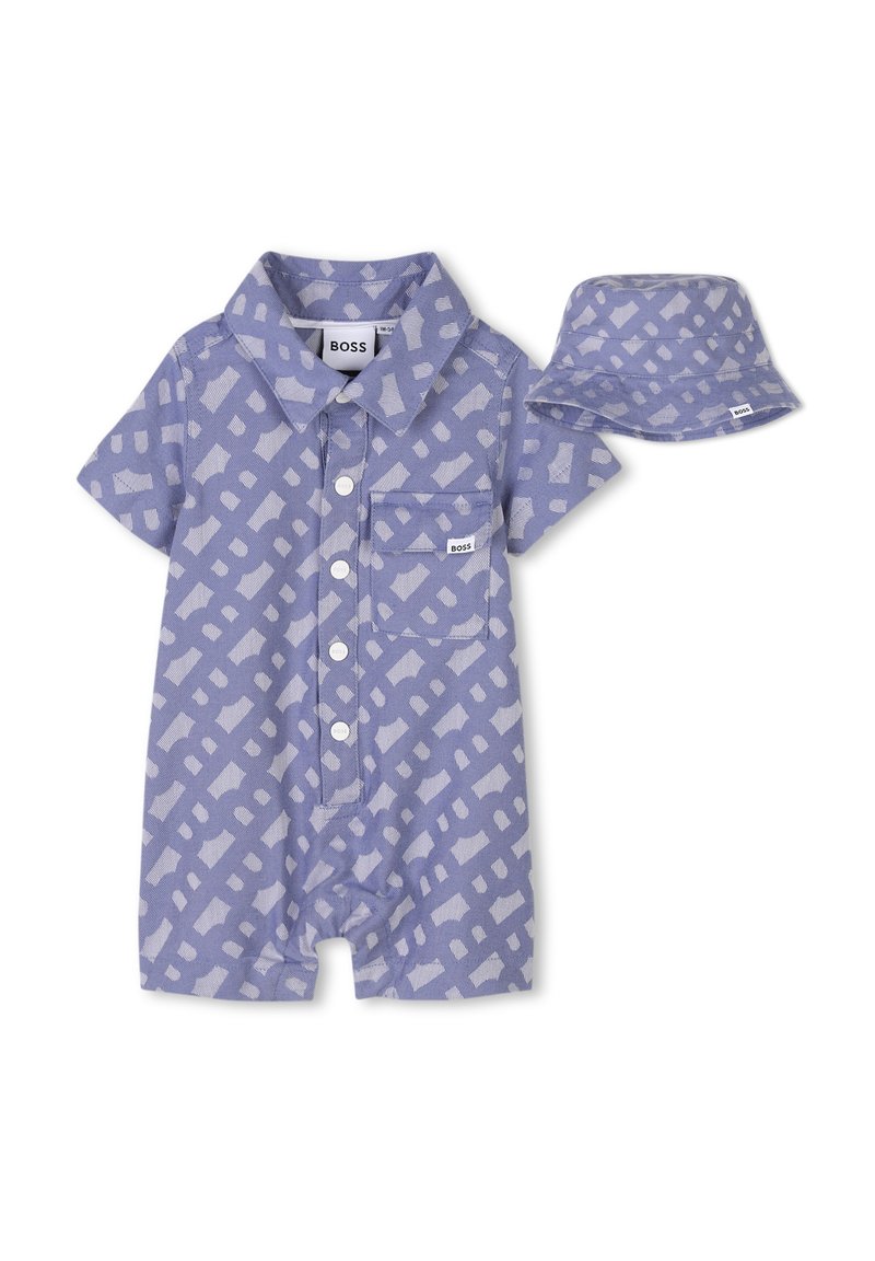 Romper corto a maniche corte di colore viola chiaro con un motivo geometrico, colletto, tasca frontale e chiusura con bottoni, abbinato a un cappellino a secchiello coordinato.