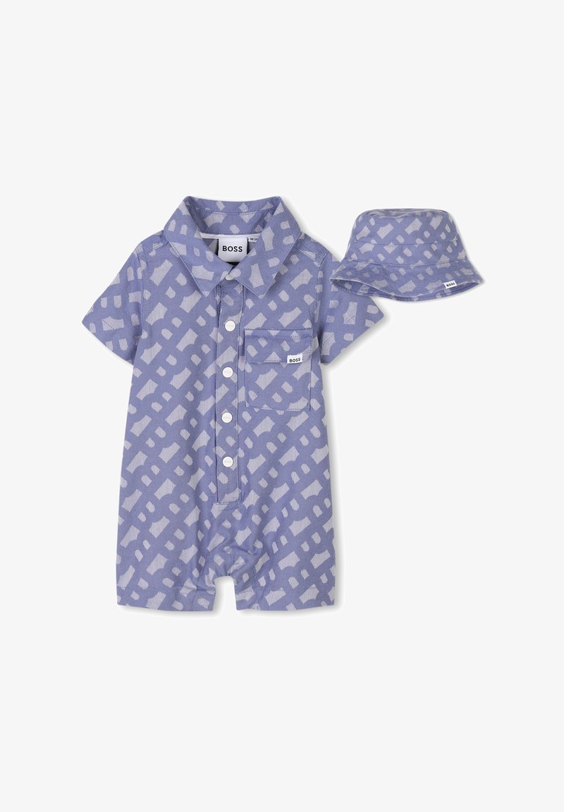 Romper corto a maniche corte di colore viola chiaro con un motivo geometrico, colletto, tasca frontale e chiusura con bottoni, abbinato a un cappellino a secchiello coordinato.