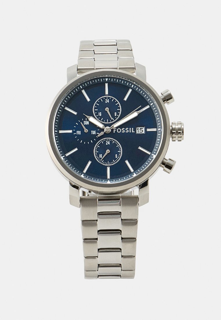 Montre en acier inoxydable argenté avec un cadran rond bleu, trois sous-cadrans pour le jour, la date et l'heure sur 24 heures, et un bracelet à maillons.