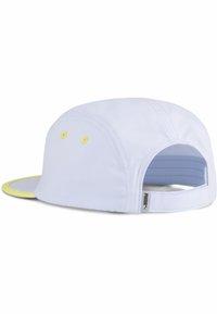 Gorra blanca con visera curvada, con acentos amarillos y orificios de ventilación. Correa trasera ajustable con etiqueta de la marca. Textura de tela suave.