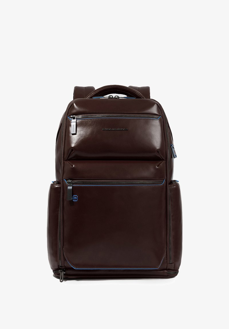 Zaino in pelle marrone con una texture liscia, molteplici tasche con cerniera e dettagli blu. Dotato di spallacci regolabili e manico superiore.