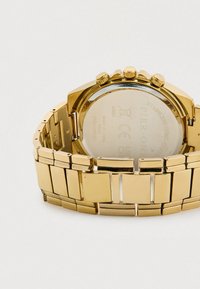 Goldene Uhr aus Edelstahl mit polierter Oberfläche, ausgestattet mit einem Gliederarmband, Chronographenzifferblättern und drei Druckknöpfen an der Seite.